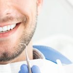 Young man at the dentist. Dental care, taking care of teeth. Picture with copy space for background.
