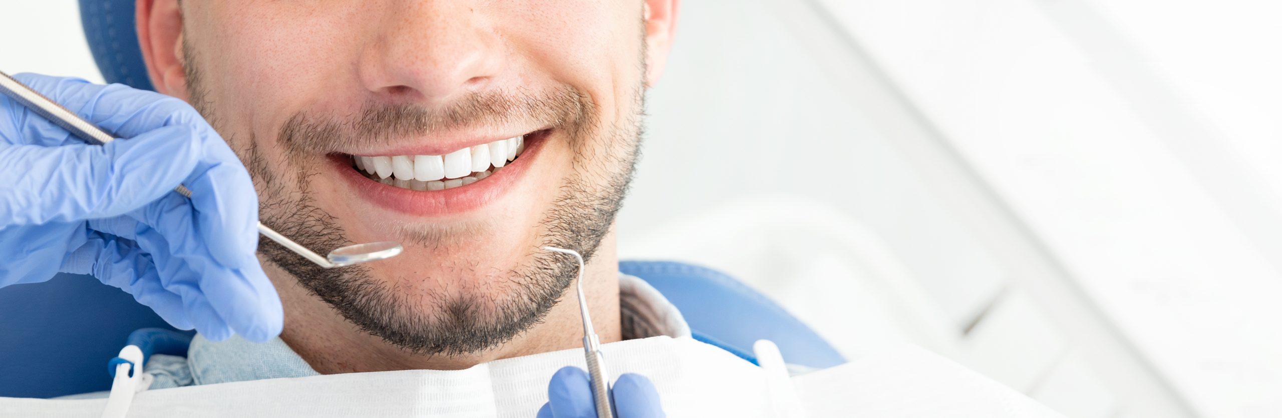 Young man at the dentist. Dental care, taking care of teeth. Picture with copy space for background.